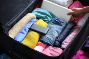 A hand packing a suitcase.