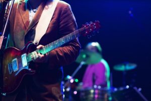 A guitarist and a drummer on stage.