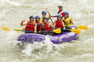 A group of people white water rafting on a river.