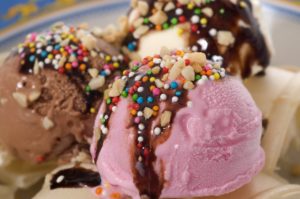 An ice cream sundae with nuts, sprinkles, and hot fudge.