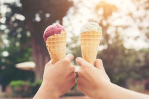 two hands holding ice cream cones