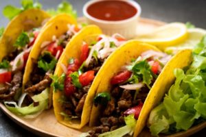 tacos topped with cilantro, tomato, and cheese