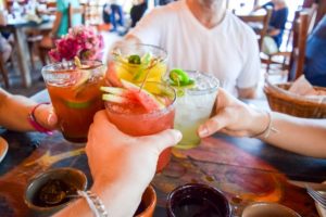 friends toasting cocktails in a bar