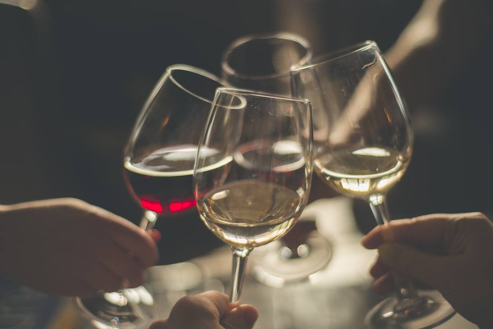 people clinking wine glasses together at a winery in gatlinburg