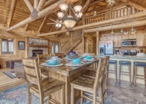 beautiful wood paneling in a cabin with a dining room table and open kitchen
